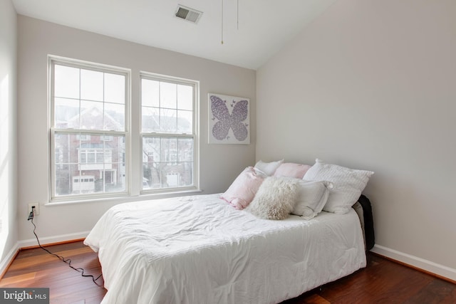 bedroom with vaulted ceiling and dark hardwood / wood-style floors