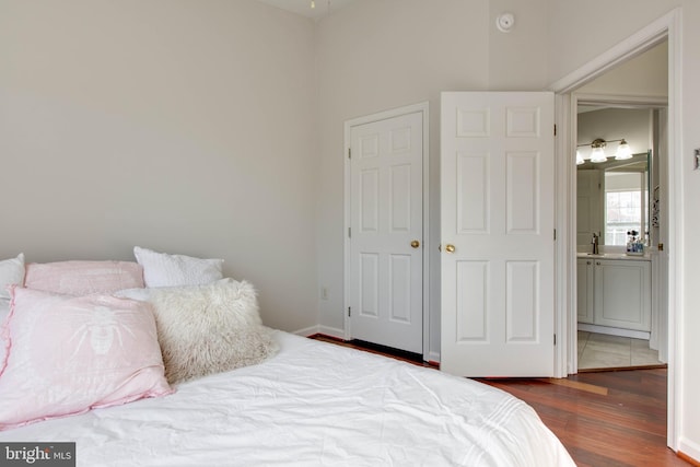 bedroom with hardwood / wood-style floors and sink