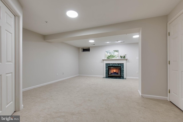 basement featuring light carpet and a premium fireplace