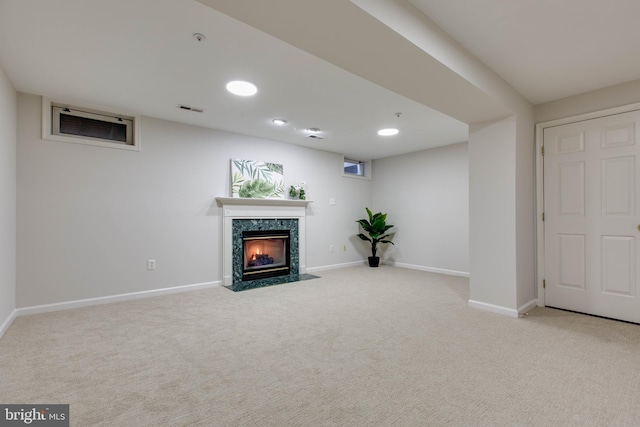 basement with light carpet and a high end fireplace