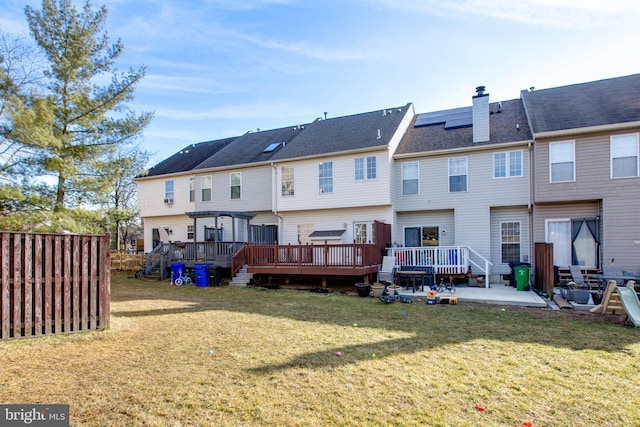 back of house with a wooden deck, a yard, and a patio