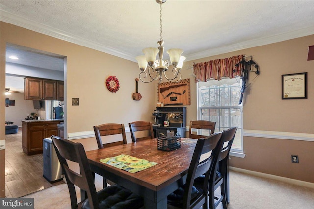 dining room with crown molding, light carpet, a textured ceiling, and a chandelier