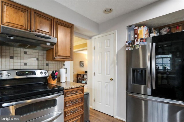 kitchen featuring stainless steel appliances, tasteful backsplash, and dark wood-type flooring