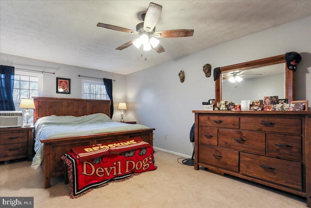 carpeted bedroom featuring ceiling fan and a textured ceiling