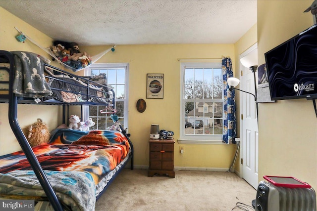 bedroom with light carpet, multiple windows, and a textured ceiling