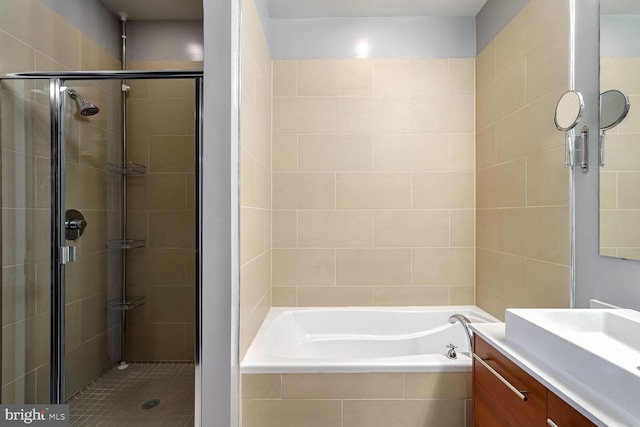 bathroom featuring vanity and independent shower and bath