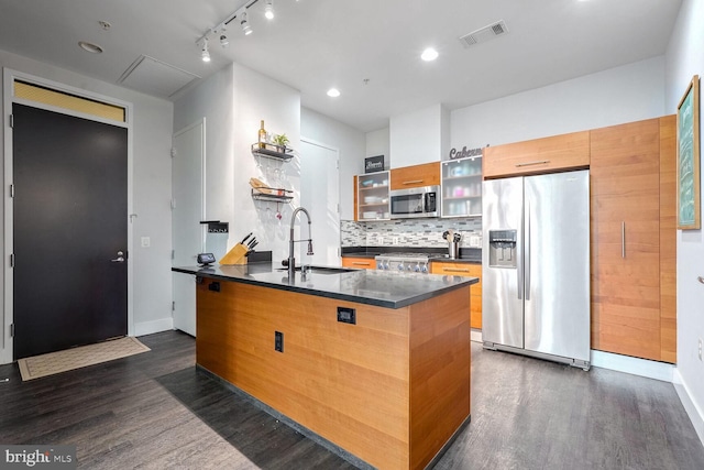 kitchen with dark hardwood / wood-style flooring, sink, a center island with sink, and appliances with stainless steel finishes