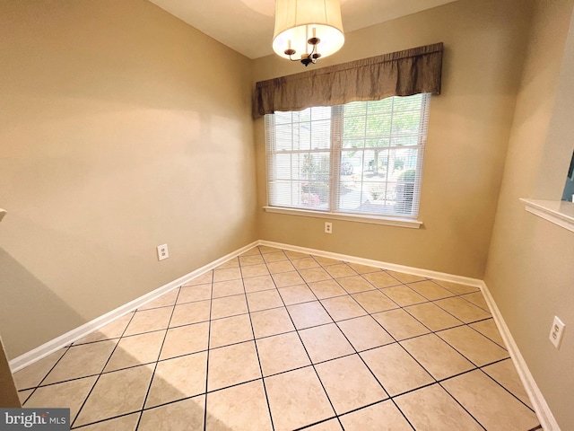 tiled empty room featuring lofted ceiling