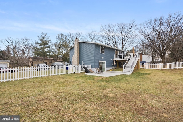 back of property featuring a wooden deck, a lawn, and a patio