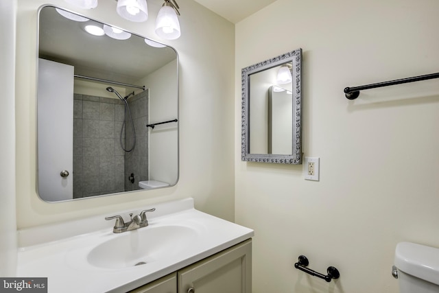 bathroom featuring toilet, walk in shower, and vanity