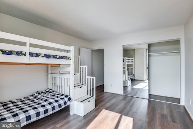 bedroom with dark wood-type flooring and a closet