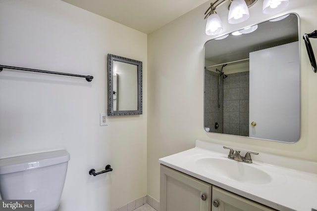 full bathroom with toilet, vanity, and baseboards