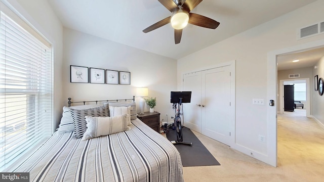 carpeted bedroom with ceiling fan and a closet