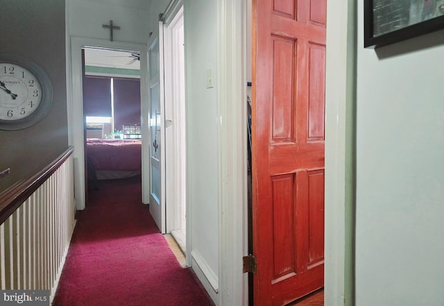 corridor featuring dark colored carpet