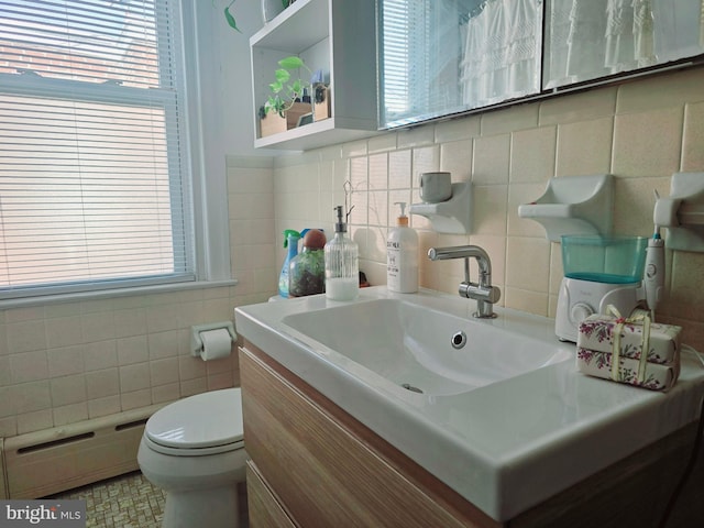 bathroom featuring a baseboard radiator, tile walls, vanity, and toilet