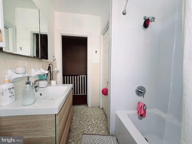 bathroom featuring vanity,  shower combination, and tile walls