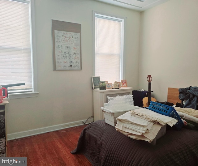 bedroom with multiple windows and dark hardwood / wood-style flooring