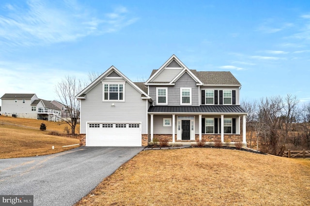 view of front of home featuring a garage, a front yard, and covered porch