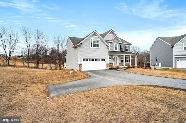 view of front of home with a garage, a front lawn, and a porch