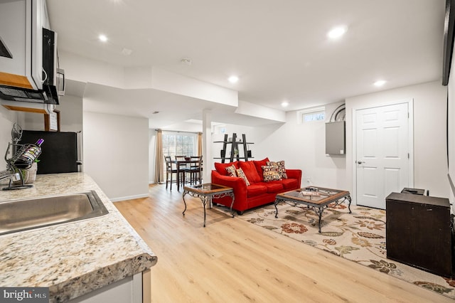 living room featuring sink and light hardwood / wood-style flooring