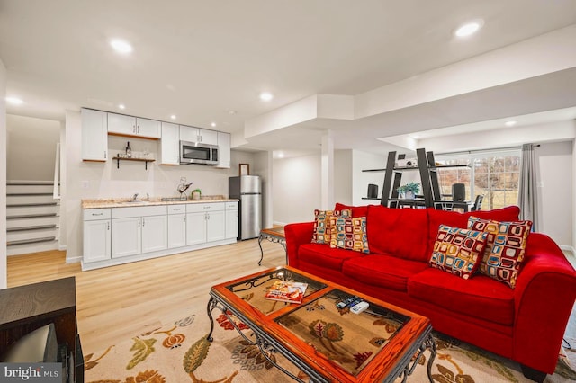 living room with sink and light hardwood / wood-style floors