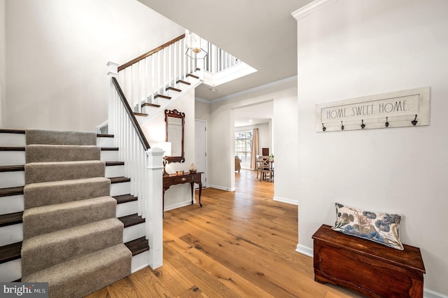 foyer entrance with wood-type flooring and crown molding