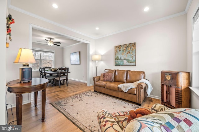 living room featuring hardwood / wood-style flooring, ornamental molding, and ceiling fan