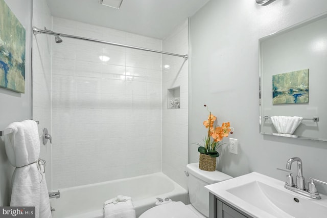 full bathroom featuring tiled shower / bath combo, vanity, and toilet