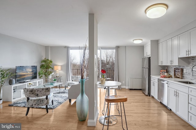 kitchen featuring white cabinetry, backsplash, sink, and appliances with stainless steel finishes