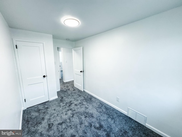 unfurnished bedroom featuring dark carpet