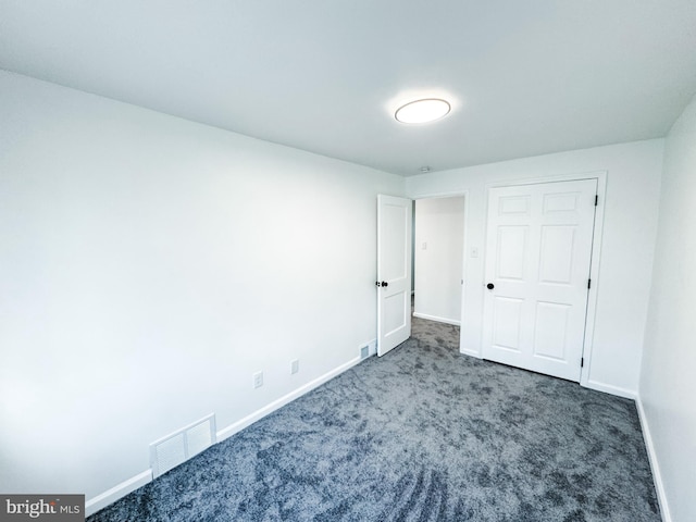 unfurnished bedroom featuring dark colored carpet