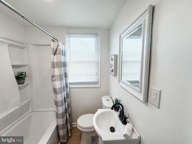 full bathroom featuring sink, shower / bath combination with curtain, and toilet