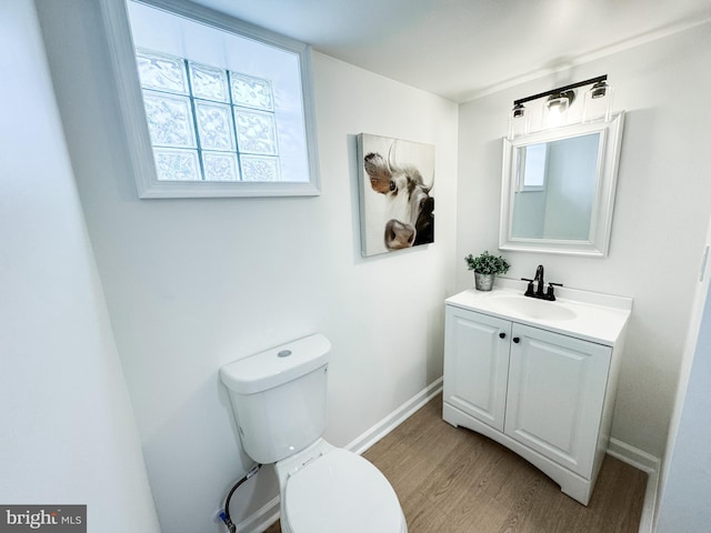 bathroom with hardwood / wood-style flooring, vanity, and toilet