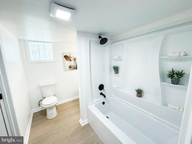 bathroom featuring hardwood / wood-style flooring, shower / bathtub combination, and toilet