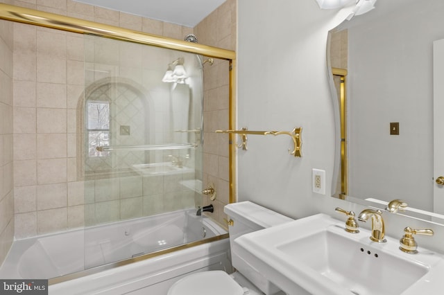 full bathroom featuring combined bath / shower with glass door, sink, and toilet