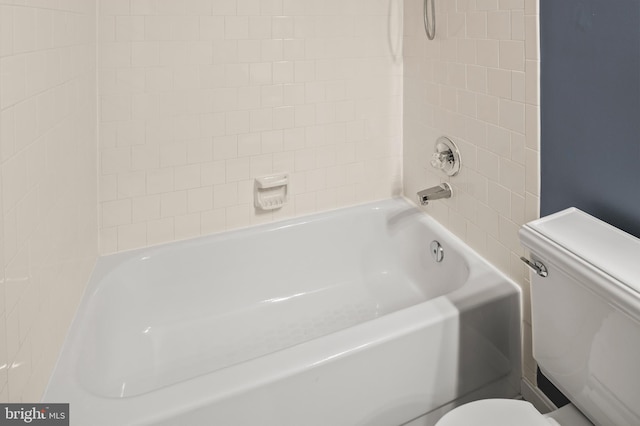 bathroom featuring toilet and tiled shower / bath combo