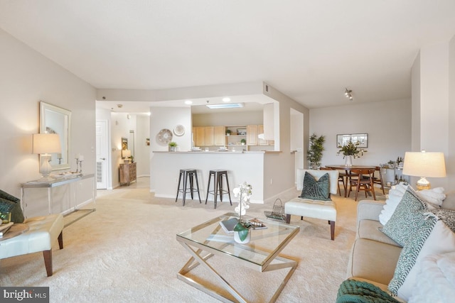 living room with baseboards and light colored carpet