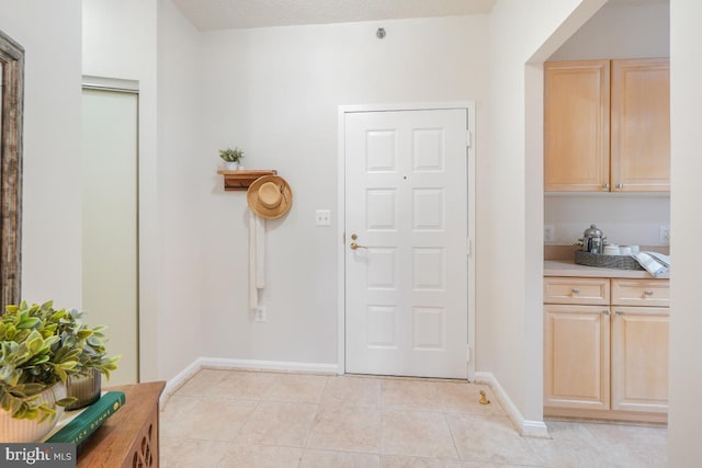 interior space featuring light tile patterned flooring and baseboards