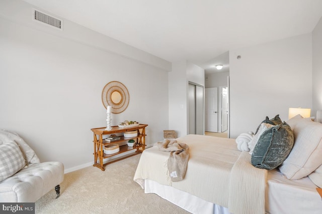 bedroom with baseboards, a closet, visible vents, and light colored carpet