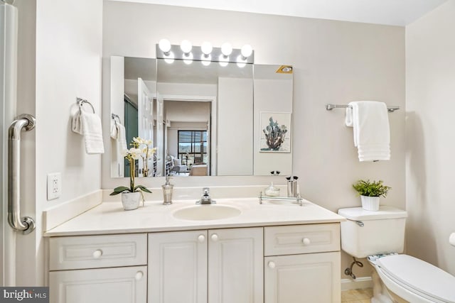 bathroom with vanity, connected bathroom, and toilet