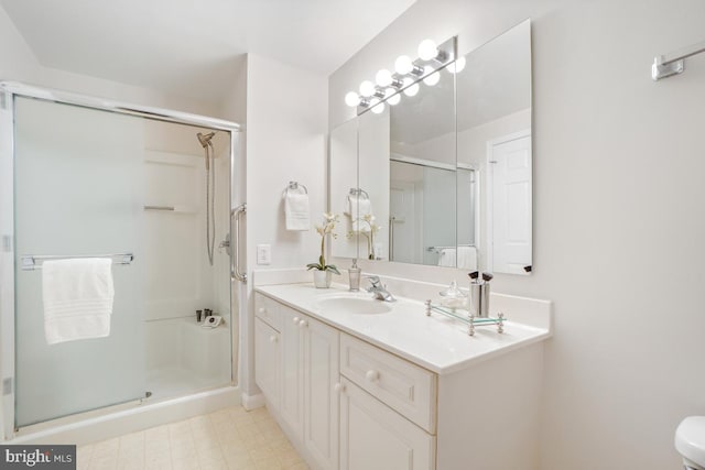 full bath with a stall shower, vanity, and tile patterned floors