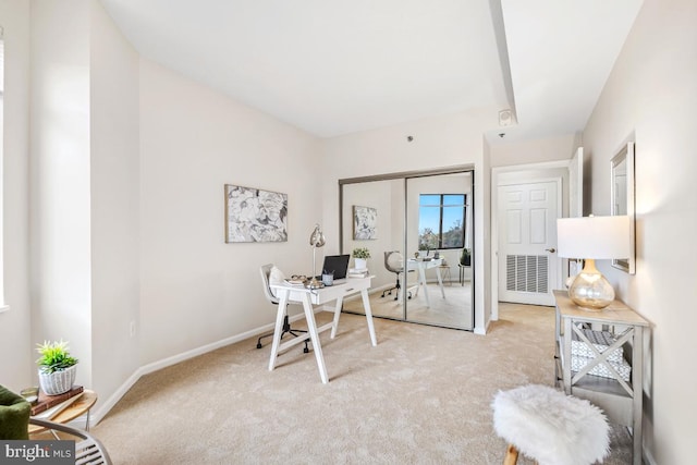 office area featuring baseboards and light colored carpet