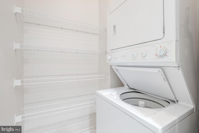 clothes washing area featuring laundry area and stacked washer / dryer