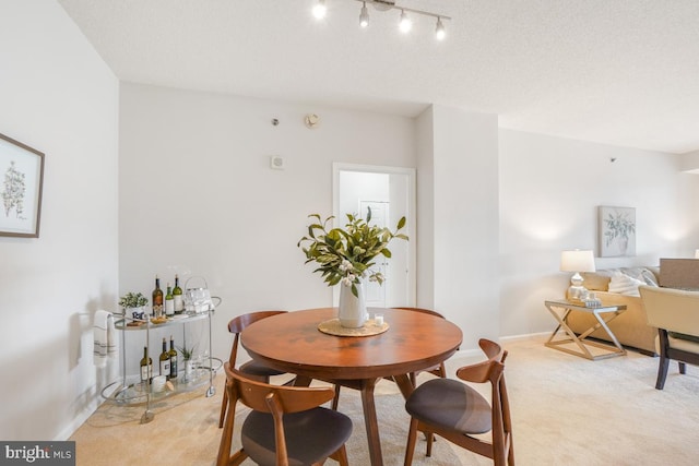 dining area with light carpet and baseboards