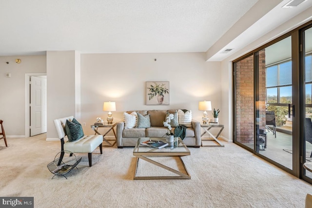 living room featuring baseboards, a textured ceiling, visible vents, and light colored carpet