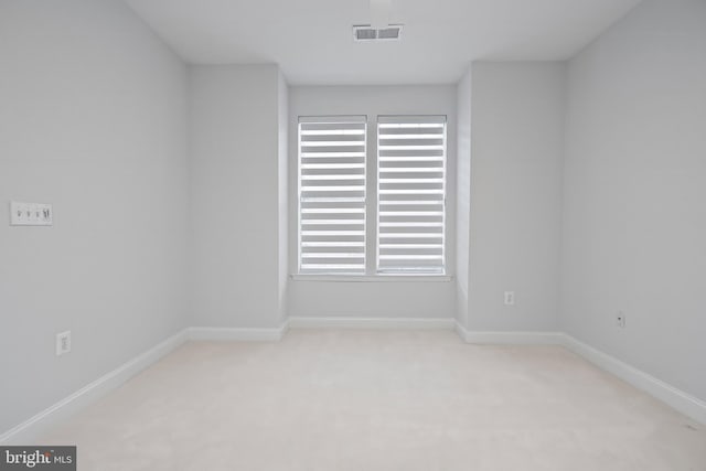 carpeted empty room featuring visible vents and baseboards