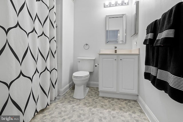 bathroom with vanity, toilet, and baseboards