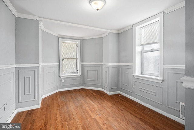 empty room with crown molding and hardwood / wood-style flooring