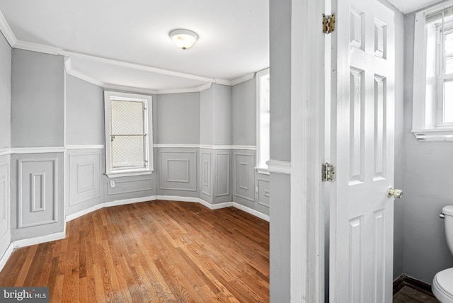 empty room with crown molding and hardwood / wood-style floors