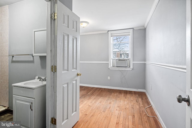 bathroom with hardwood / wood-style flooring, ornamental molding, and vanity